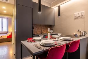 cocina con mesa de comedor con sillas rojas en Duomo a 2 fermate - Tiny Apartment in Pta Venezia, en Milán 4 fotos más