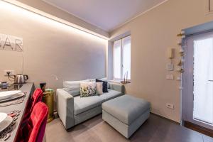 una sala de estar con un sofá y una silla en Duomo a 2 fermate - Tiny Apartment in Pta Venezia, en Milán