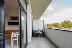 - Balcón con mesa y silla en un edificio en Apartment Mountain 40m2 balkon antresola 4 osoby, en Cracovia