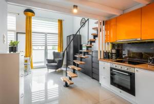 una cocina con armarios naranjas y una silla. en Apartment Mountain 40m2 balkon antresola 4 osoby, en Cracovia