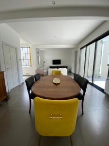 comedor con mesa de madera y sillas amarillas en Casa remodelada con pileta y parrilla en Tandil