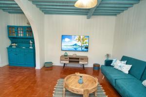 un soggiorno con un divano blu e un tavolino da caffè di H2O - próximo das melhores praias da costa sul a Vila Franca do Campo