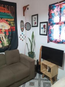 a living room with a couch and a flat screen tv at Hostel Resende in Resende