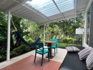 a porch with a hammock and a table and chairs at Casa vacacional ideal para familias / Los Reyes in Loja