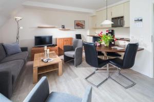 a living room with a couch and a table and chairs at Fischer Haus in Norderney