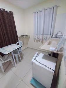 a small white room with a desk and a chair at Suites para casais na praça Oswaldo Cruz in Cabo Frio