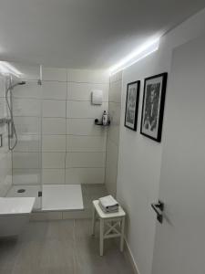 a white bathroom with a shower and a sink at Anderswo Bad Aibling in Bad Aibling