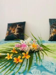 a bouquet of flowers sitting on top of a bed at Vairou Lodge Bora Bora in Bora Bora