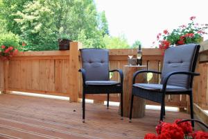 two chairs and a table on a deck at Chata Škerda - Zuberec in Zuberec