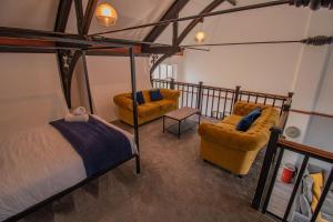 a bedroom with a bed and two chairs at Boutique Penthouse Apartment in Historic Hull HU1 - sleeps 6 in Hull