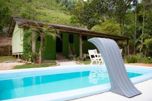 una piscina con un tobogán junto a una casa en Casa de Campo com piscina em Marechal Floriano ES, en Marechal Floriano