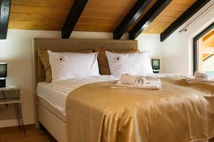 a bedroom with a large bed with towels on it at The View Luxury Chalet in Jahorina