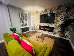 a living room with a yellow couch and a tv at 1 West End Boutique Apartment in Bowness-on-Windermere