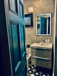 a bathroom with a blue door and a sink at 1 West End Boutique Apartment in Bowness-on-Windermere