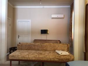 duas camas num quarto com uma televisão na parede em ANTIQUE HOUSE (ANTALYA CENTER) em Antália