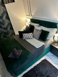 - un lit avec une tête de lit verte et des oreillers dans l'établissement Apartamenty Kielce- APARTAMENT SZMARAGD przy zalew kielecki, faktura, à Kielce