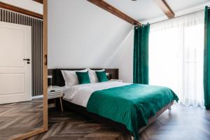 ルメテアにあるKARL's Cabin by Black & White Panoramicのベッドルーム1室(緑のシーツと鏡付きのベッド1台付)