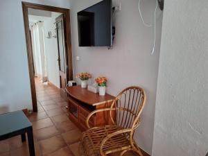 Una habitación con una mesa y un televisor en una pared. en Mi ilusión, en Grazalema
