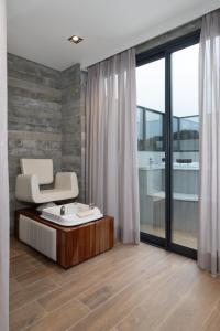 a bathroom with a chair and a bath tub at Brava Mundo Hotel Boutique OFICIAL in Itajaí
