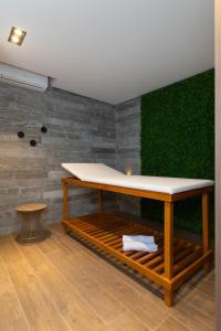 a table in a room with a green wall at Brava Mundo Hotel Boutique OFICIAL in Itajaí