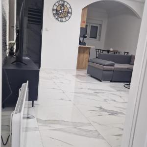 a living room with a marble floor and a clock at APARTMAN MAYA 2 in Buzin