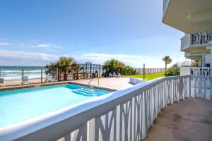 a balcony with a swimming pool and the ocean at Paloma Penthouse in Ormond Beach