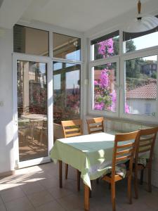a dining room with a table and chairs and windows at Apartments Rubinić in Jelsa