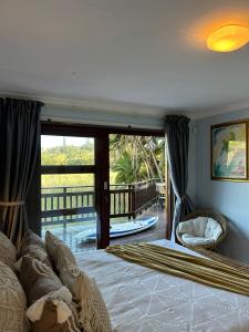 Un dormitorio con una cama grande y un balcón. en QUi TAMEM SUN, en Southbroom