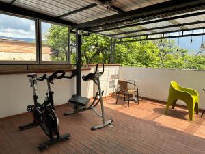 een terras met twee hometrainers en een tafel en stoelen bij Laureles Guest House LGH Hotel in Medellín
