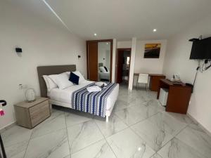 een slaapkamer met een bed, een tafel en een bureau bij Residencial Santo Amaro in Tarrafal