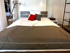 a large bed with two red pillows on it at BeeFree WhirlpoolSuiteXL33-FreeParking-FastWiFi in Passau