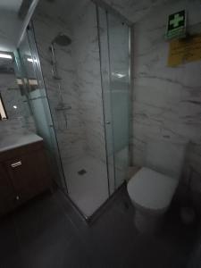 a bathroom with a glass shower and a toilet at Casas da Bela - Bairro Típico na Nazaré in Nazaré