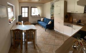 a kitchen and living room with a table and a blue couch at Ferienwohnung am Schloss in Fechenbach