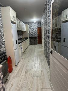 una cucina con elettrodomestici bianchi e pavimenti in legno di Lovely house in Luanda Centre with treadmill a Luanda