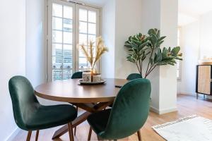 a dining room with a wooden table and green chairs at New premium flat - Malaga Center in Málaga