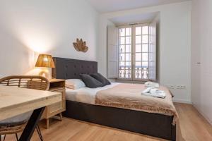 a bedroom with a bed and a desk and a window at New premium flat - Malaga Center in Málaga