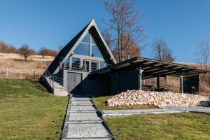 ein Haus mit einem Stapel Feuerholz davor in der Unterkunft KARL's Cabin by Black & White Panoramic in Rimetea