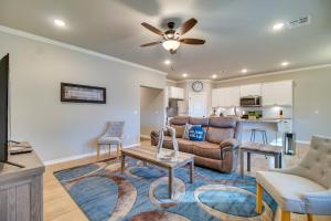 a living room with a couch and a ceiling fan at Charming Grove Home with Deck Near Grand Lake! in Grove