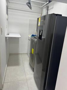 a kitchen with a refrigerator and a trash can at Espacio acogedor en Piedecuesta, Santander. in Piedecuesta
