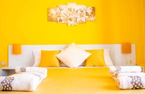 a yellow room with a couch with pillows on it at Blu Mare Lampedusa Bed And Breakfast in Lampedusa