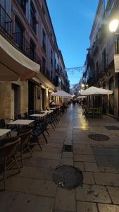an empty street with tables and chairs and umbrellas at VIVIENDA REAL CON ENCANTO in Úbeda
