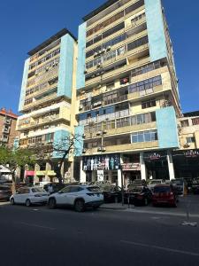 a large building with cars parked in front of it at Lovely house in Luanda Centre with treadmill in Luanda