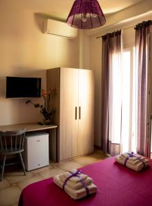 a bedroom with a bed and a cabinet and a desk at Blu Mare Lampedusa Bed And Breakfast in Lampedusa
