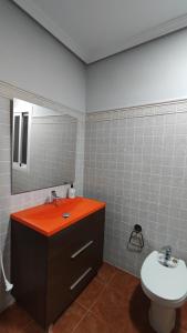 a bathroom with a sink and a toilet and a mirror at VIVIENDA REAL CON ENCANTO in Úbeda