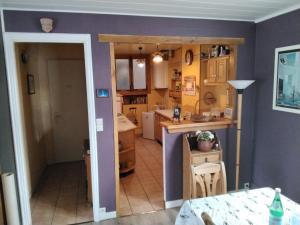 una cucina con pareti viola e un tavolo in una stanza di Appartement centre ville classé unesco a Le Havre
