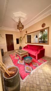 sala de estar con sofá rojo y alfombra en RIAD GJULJA, en Marrakech