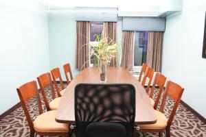 a dining room table with a vase of flowers on it at Copley Inn & Suites, Copley - Akron in Akron