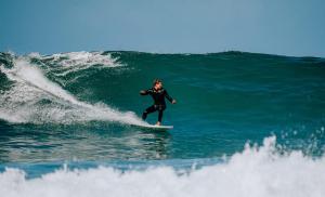 Eine Person, die eine Welle auf einem Surfbrett im Ozean reitet in der Unterkunft Endless Summer Vibes in Adeje
