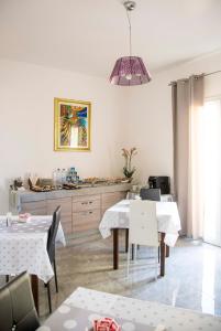 a dining room with white tables and a pendant light at Blu Mare Lampedusa Bed And Breakfast in Lampedusa