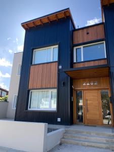 a black house with a wooden front door at Hermoso Departamento in Esquel
